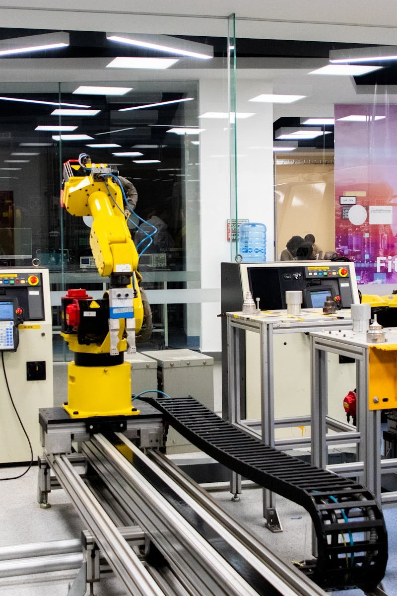 Robotic arms in action within a modern industrial control room setting, showcasing technology and production.